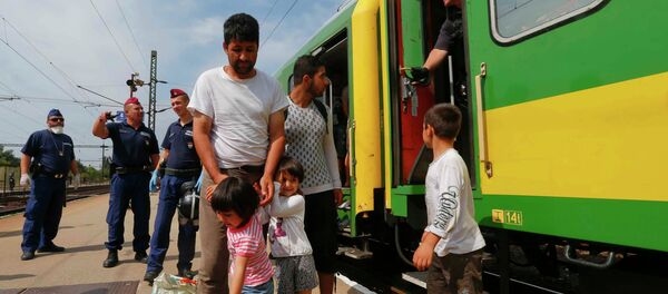 Migrants stand outside a train at the railway station in the town of Bicske, Hungary, September 3, 2015 - Sputnik International