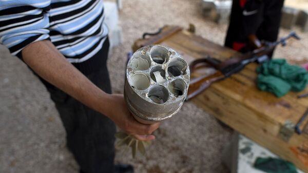 A Libyan rebel fighter shows a spent cluster munition mortar bomb near the frontline of Tripoli Street in Misrata on April 20, 2011 - Sputnik International