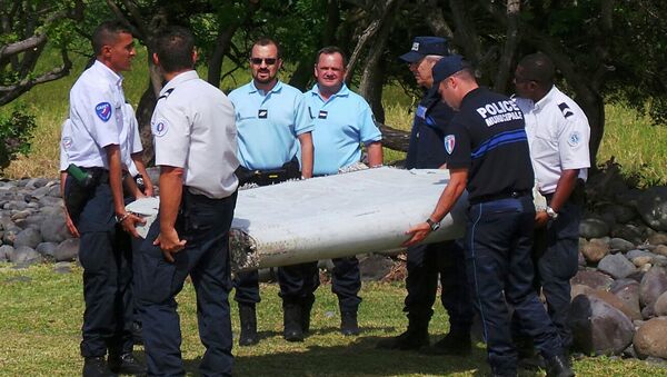 French gendarmes and police carry a large piece of plane debris which was found on the beach in Saint-Andre, on the French Indian Ocean island of La Reunion, in this picture taken July 29, 2015 - Sputnik International