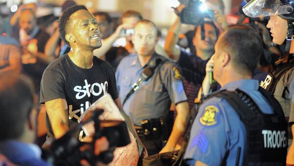 A protester (L) speaks emotionally at a police officer during a protest down a street in Ferguson, Missouri on August 19, 2014 - Sputnik International