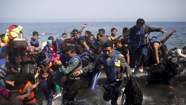 Syrian refugees jump off a dinghy as they arrive on the Greek island of Lesbos September 3, 2015 - Sputnik International