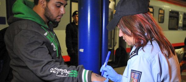 A Czech police officer writes a number on the skin of a refugee in Breclav, Czech Republic September 1, 2015 - Sputnik International