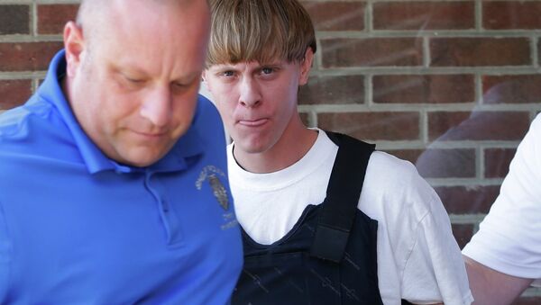 FILE - In this June 18, 2015, file photo, Charleston, S.C., shooting suspect Dylann Storm Roof, center, is escorted from the Sheby Police Department in Shelby, N.C. - Sputnik International