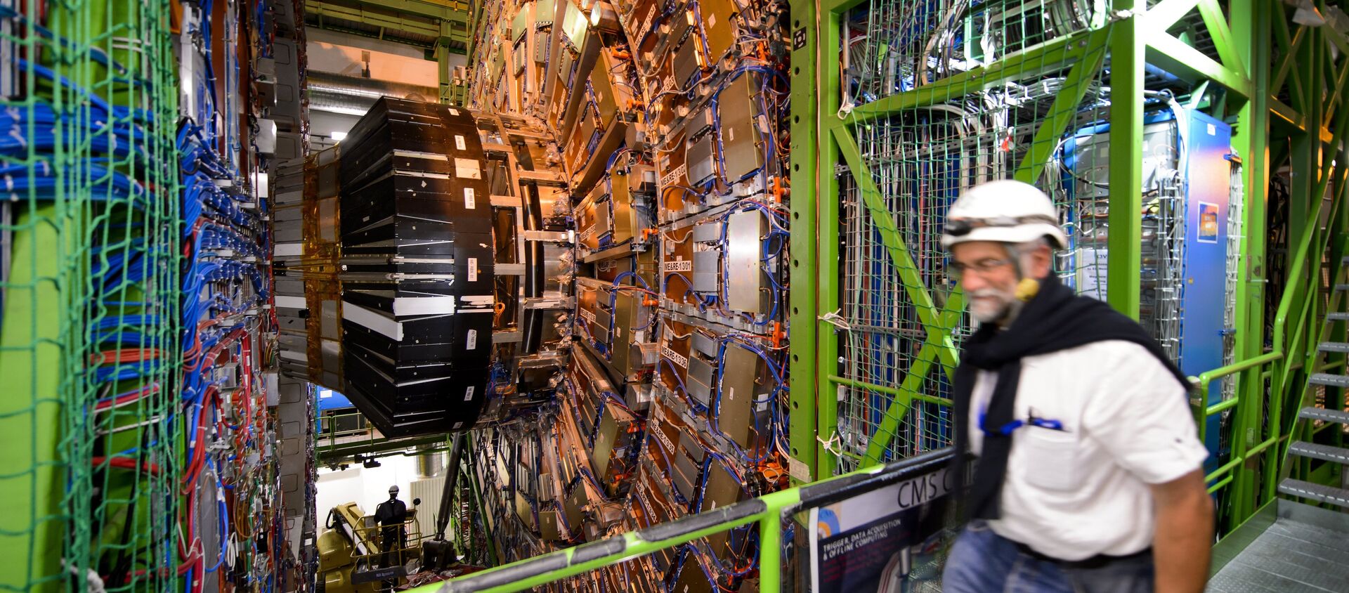 A worker walks past the CERN's Compact Muon Solenoid (CMS), a general-purpose detector at the Large Hadron Collider (LHC), during maintenance works - Sputnik International, 1920, 24.03.2021