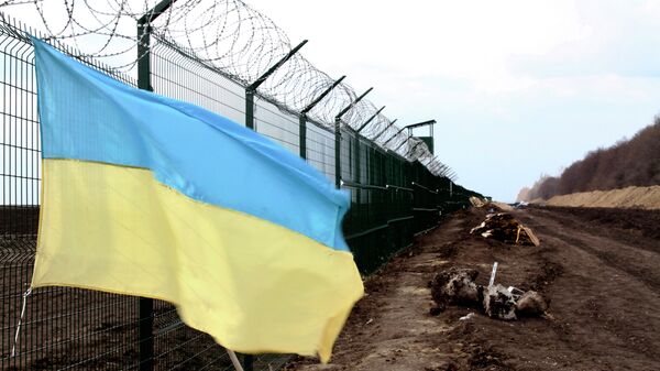 In this photo taken on Saturday, April 18, 2015, a Ukrainian national flag is attached to the fence on the Ukrainian-Russian border near Hoptivka, Kharkiv region, eastern Ukraine - Sputnik International