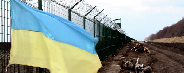 In this photo taken on Saturday, April 18, 2015, a Ukrainian national flag is attached to the fence on the Ukrainian-Russian border near Hoptivka, Kharkiv region, eastern Ukraine In this photo taken on Saturday, April 18, 2015, a Ukrainian national flag is attached to the fence on the Ukrainian-Russian border near Hoptivka, Kharkiv region, eastern Ukraine - Sputnik International