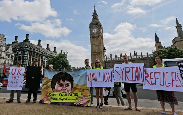 Protesters hold banners during an Amnesty International protest in Parliament Square to urge the British government to do more to help Syrian refugees, London, Saturday, July 11, 2015. Protesters hold banners during an Amnesty International protest in Parliament Square to urge the British government to do more to help Syrian refugees, London, Saturday, July 11, 2015. - Sputnik International