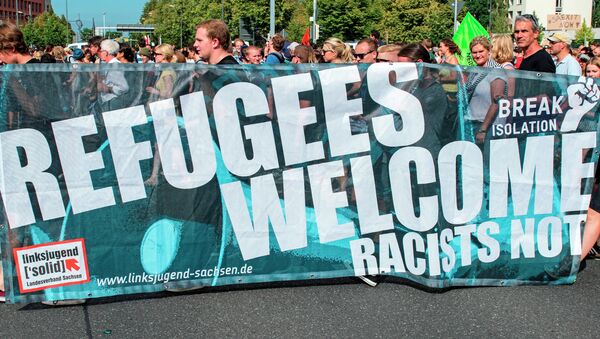 Protesters demonstrate with a banner 'Refugees welcome!' in Dresden, eastern Germany, Saturday, Aug. 29, 2015. A refugee shelter was attacked by far-right protesters in Heidenau near Dresden over the last weekend. - Sputnik International