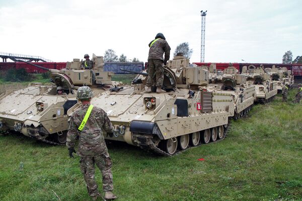 Members of the US Army 1st Brigade, 1st Cavalry Division, unload Bradley Fighting Vehicles at the railway station near the Rukla military base in Lithuania, on October 4, 2014 Members of the US Army 1st Brigade, 1st Cavalry Division, unload Bradley Fighting Vehicles at the railway station near the Rukla military base in Lithuania, on October 4, 2014 - Sputnik International