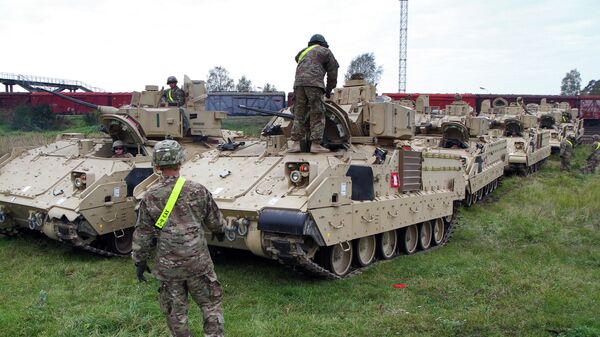 Members of the US Army 1st Brigade, 1st Cavalry Division, unload Bradley Fighting Vehicles at the railway station near the Rukla military base in Lithuania, on October 4, 2014 - Sputnik International