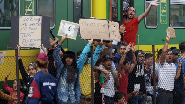 People shout slogans outside a train that was stopped in Bicske, Hungary, Friday, Sept. 4, 2015. - Sputnik International