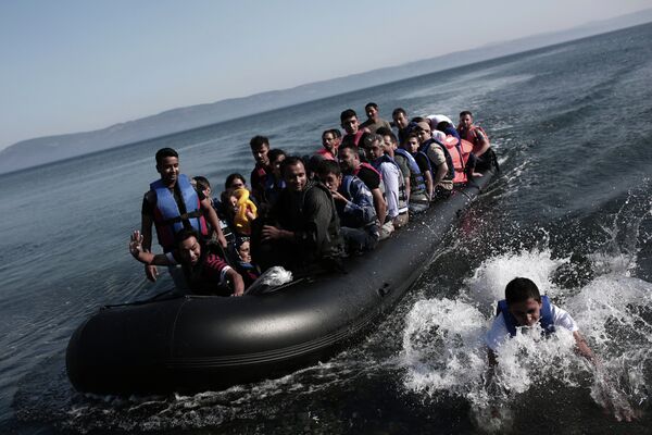 Refugees coming from Turkey land on the shores of the Greek island Lesbos in an inflatable boat on September 4, 2015 - Sputnik International
