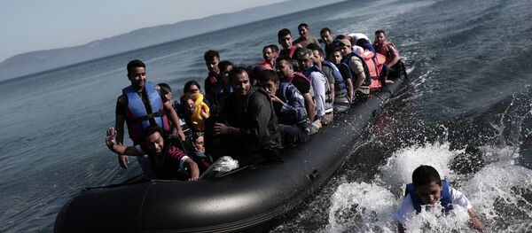 Refugees coming from Turkey land on the shores of the Greek island Lesbos in an inflatable boat on September 4, 2015 - Sputnik International