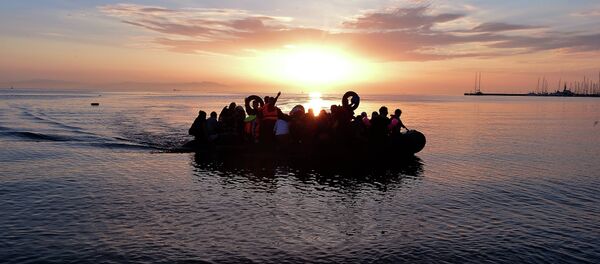 Syrian migrants arrive on an overcrowded dinghy to the coast of the southeastern Greek island of Kos from Turkey, on August 15, 2015 - Sputnik International