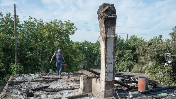 A man in the village of Oleksandrivka, Donetsk Region where houses were destroyed and people wounded during a mortar shelling. - Sputnik International