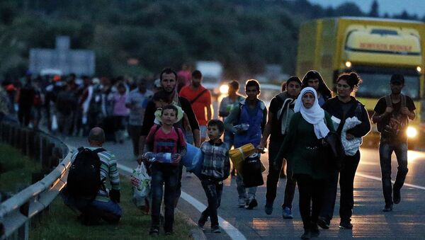 People walk in a long line along the highway near Budapest, Hungary, heading for the Austrian border. - Sputnik International