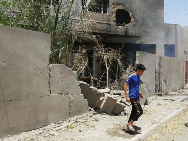 Abdullah Ahmed walks outside his home that was damaged in a bombing in Fallujah, Iraq. The U.S. and its coalition allies have carried out more than 1,000 strikes in Iraq since its campaign began in August - as well as hundreds more by American and Arab air forces in neighboring Syria. Abdullah Ahmed walks outside his home that was damaged in a bombing in Fallujah, Iraq. The U.S. and its coalition allies have carried out more than 1,000 strikes in Iraq since its campaign began in August - as well as hundreds more by American and Arab air forces in neighboring Syria. - Sputnik International