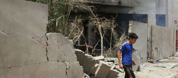 Abdullah Ahmed walks outside his home that was damaged in a bombing in Fallujah, Iraq. The U.S. and its coalition allies have carried out more than 1,000 strikes in Iraq since its campaign began in August - as well as hundreds more by American and Arab air forces in neighboring Syria. - Sputnik International
