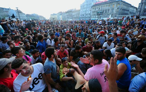 Migrants sit in front of Budapest's Keleti (East) railway station on September 2, 2015 Migrants sit in front of Budapest's Keleti (East) railway station on September 2, 2015 - Sputnik International