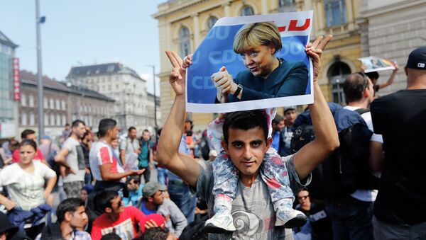 A man holds up a poster of German Chacellor Angela Merkel before starting a march out of Budapest, Hungary, Friday, Sept. 4, 2015 - Sputnik International
