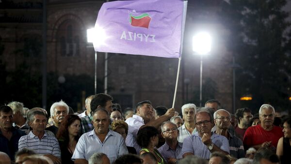 A leftist Syriza party supporter waves a party flag during a speech of former Greek Prime Minister and leader of the party Alexis Tsipras (not pictured) at a pre-election rally in the western suburb of Egaleo, in Athens, Greece, in this September 3, 2015 file photo - Sputnik International