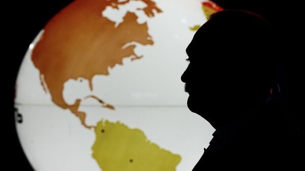 Man stands before world map. File photo. - Sputnik International