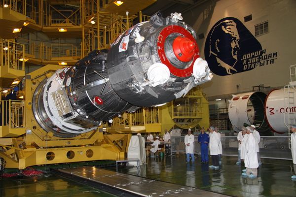 Specialists of RSC Energia work to install the payload shroud on a manned Soyuz TMA-02M spacecraft in the assembly and test complex at Baikonur Cosmodrome, where work proceeds on building a Soyuz-FG space rocket - Sputnik International