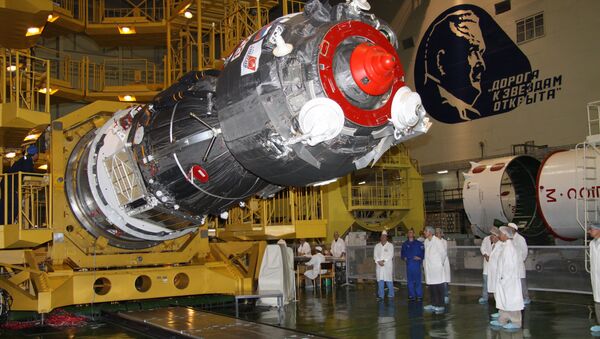 Specialists of RSC Energia work to install the payload shroud on a manned Soyuz TMA-02M spacecraft in the assembly and test complex at Baikonur Cosmodrome, where work proceeds on building a Soyuz-FG space rocket - Sputnik International