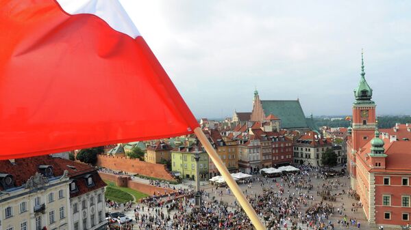 A Polish national flag waves above the Zamkowy Square as people stop to commemorate the 70th anniversary of the 1944 Warsaw Uprising, in Warsaw, Poland, Friday, Aug. 1, 2014 - Sputnik International