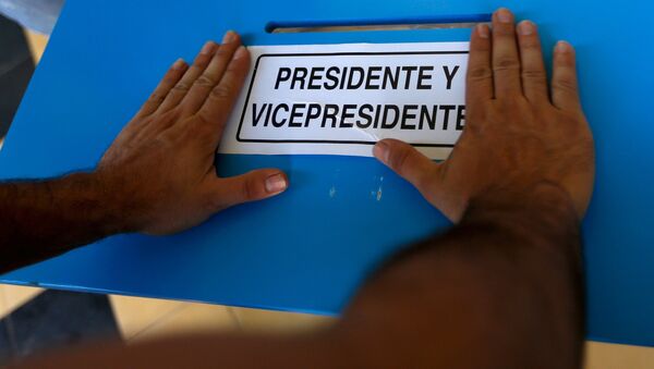 A electoral worker places a sign to mark the ballot box for President and Vice-President while installing a polling station at a school in Guatemala City, September 5, 2015 - Sputnik International