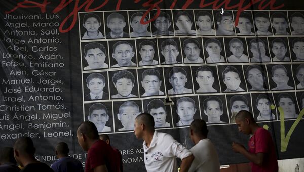 Newly enrolled students stand near a banner showing the photographs of the 43 missing students of the Ayotzinapa teachers' training college, at the college in Tixtla, on the outskirts oft Chilpancingo, in the Mexican state of Guerrero, August 16, 2015 - Sputnik International