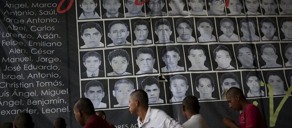Newly enrolled students stand near a banner showing the photographs of the 43 missing students of the Ayotzinapa teachers' training college, at the college in Tixtla, on the outskirts oft Chilpancingo, in the Mexican state of Guerrero, August 16, 2015 Newly enrolled students stand near a banner showing the photographs of the 43 missing students of the Ayotzinapa teachers' training college, at the college in Tixtla, on the outskirts oft Chilpancingo, in the Mexican state of Guerrero, August 16, 2015 - Sputnik International