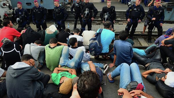 Riot police stand on the train track as they monitor migrants and refugees at the Keleti (eastern) railway station in Budapest on September 1, 2015 - Sputnik International