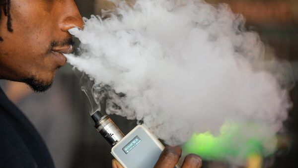 A man smokes an electronic cigarette vaporizer, also known as an e-cigarette, in Toronto, August 7, 2015 - Sputnik International