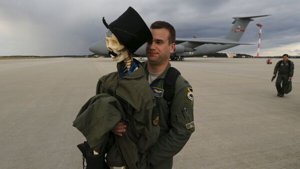 Eric Kordus, a F-22 Raptor fighter jet pilot of the 95th Fighter Squadron from Tyndall, Florida, carries Mr. Bone, the squadron's mascot consisting of a dressed-up plastic skeleton with a stovepipe hat and a moustache, after a refuelling mission of a KC-135 Stratotanker from the NATO airbase of Aemari, Estonia to Spangdahlem, Germany September 4, 2015 - Sputnik International