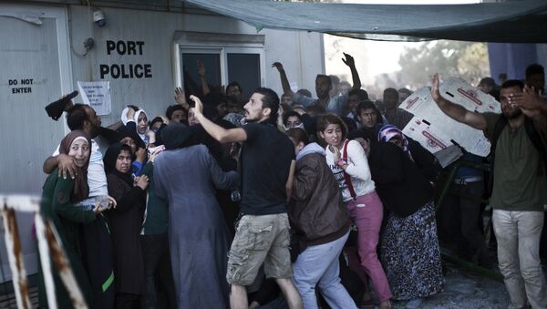 Migrants try to protect themselves from stones as Afghans and Syrian migrants scuffle over priority at a registration queue at the port of Mytilene on the Greek Aegean island of Lesbos on September 6, 2015 - Sputnik International