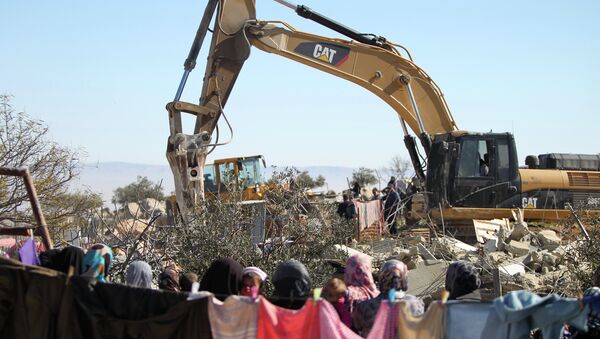 Palestinian women watches on as an Israeli army bulldozer with a demolition permit pulls down the house of the Palestinian Raba'ai family which Israeli authorities said was build without a permit, in Al-Dirat south of Yatta village near the West Bank town of Hebron on January 20, 2015. - Sputnik International