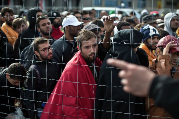 People wait in line to board buses organized by the Austrian government in Hegyeshalom, Hungary, Sunday, Sept. 6, 2015. People wait in line to board buses organized by the Austrian government in Hegyeshalom, Hungary, Sunday, Sept. 6, 2015. - Sputnik International