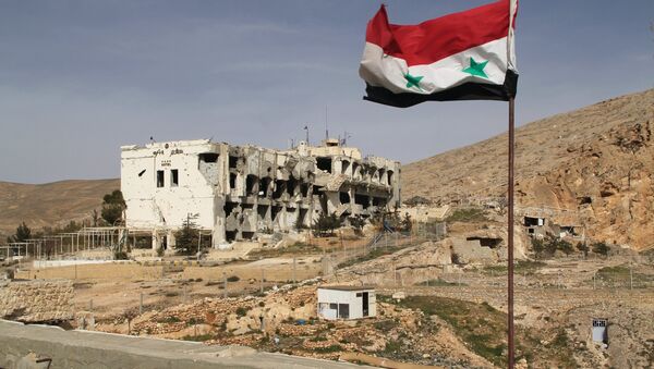 A Syrian flag on the background of ruined houses in the Syrian town of Maaloula, 55 km from Damascus, which was twice captured and looted by Jabhat al-Nusra militants. - Sputnik International