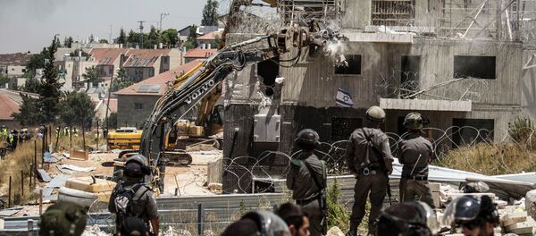 Israeli officers from the Border Patrol watch over the demolition of a building at the Jewish settlement of Beit El, near the West Bank town of Ramallah, Wednesday, July 29, 2015. Israeli officers from the Border Patrol watch over the demolition of a building at the Jewish settlement of Beit El, near the West Bank town of Ramallah, Wednesday, July 29, 2015. - Sputnik International