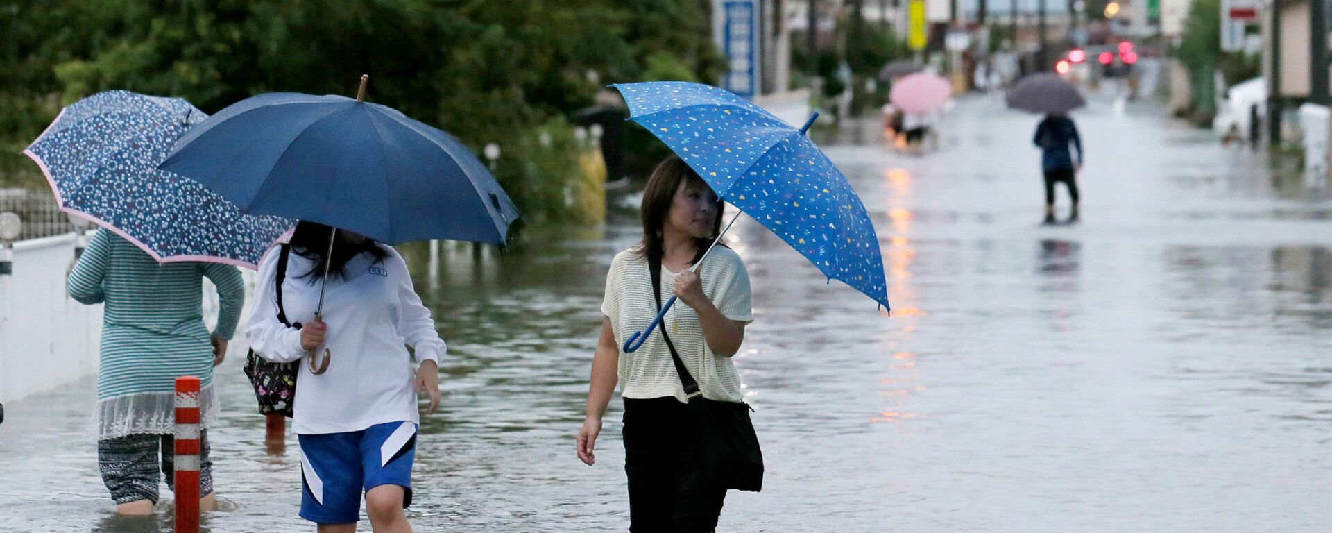 Pedestrians wade through flood waters on a road following torrential rains brought on by Typhoon Etau in Hamamatsu, Shizuoka prefecture, central Japan on September 8, 2015 - Sputnik International, 1920, 22.09.2024