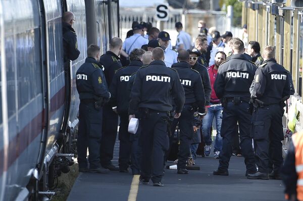 Danish police guard a train carrying migrants, mainly from Syria and Iraq, at Rodby train station, south of Denmark, September 9, 2015. The migrants, hoping to get to Sweden, arrived at Rodby on Tuesday night and refused to leave the train to get registered in Denmark. Danish police guard a train carrying migrants, mainly from Syria and Iraq, at Rodby train station, south of Denmark, September 9, 2015. The migrants, hoping to get to Sweden, arrived at Rodby on Tuesday night and refused to leave the train to get registered in Denmark. - Sputnik International