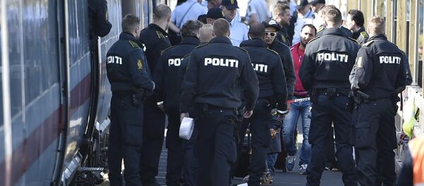 Danish police guard a train carrying migrants, mainly from Syria and Iraq, at Rodby train station, south of Denmark, September 9, 2015. The migrants, hoping to get to Sweden, arrived at Rodby on Tuesday night and refused to leave the train to get registered in Denmark. - Sputnik International