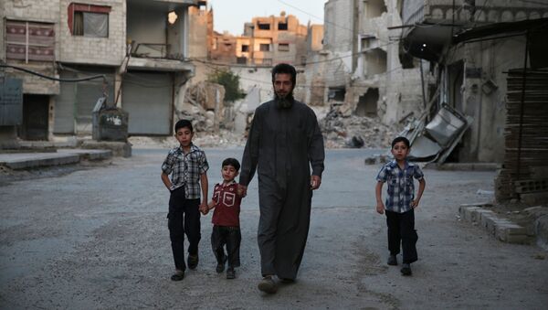 A Syrian man heads to a mosque with children in the rebel-held area of Douma, east of the capital Damascus - Sputnik International