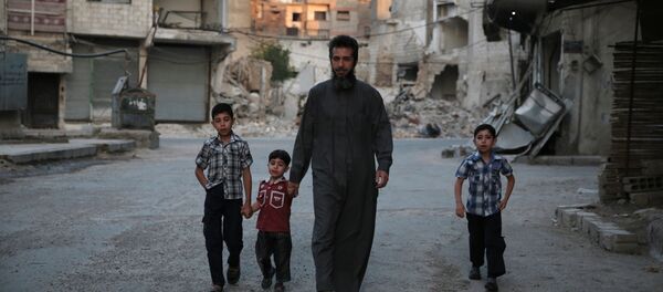 A Syrian man heads to a mosque with children in the rebel-held area of Douma, east of the capital Damascus - Sputnik International