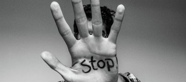 The word 'stop' written on a man's hand - Sputnik International