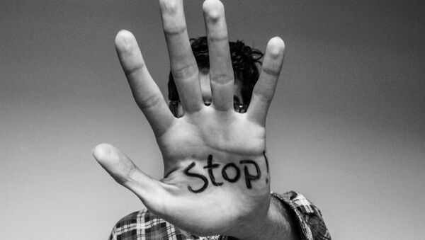 The word 'stop' written on a man's hand - Sputnik International
