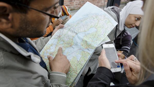 A migrant checks a map of Sweden after arriving at Malmo train station in Sweden September 10, 2015. - Sputnik International