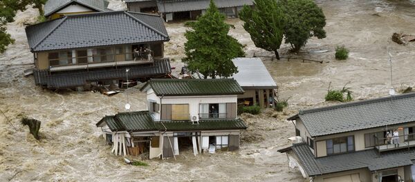 People wait to be rescued as floodwaters caused by Typhoon Etau engulf their homes. People wait to be rescued as floodwaters caused by Typhoon Etau engulf their homes. - Sputnik International