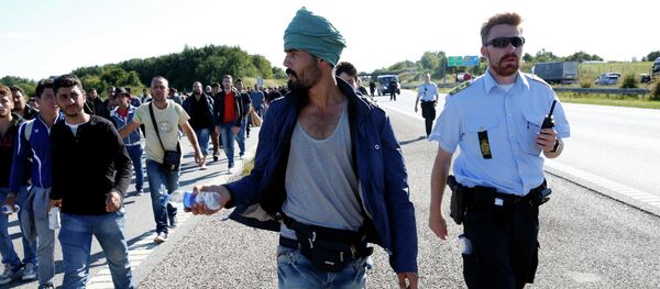 Migrants walk north on the highway in Southern Denmark, Wednesday, Sept. 9, 2015 Migrants walk north on the highway in Southern Denmark, Wednesday, Sept. 9, 2015 - Sputnik International